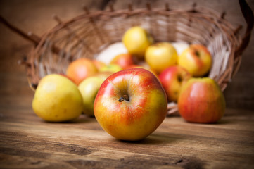 Basket with apples on wooden background