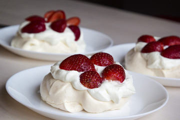  Pavlova cakes with meringue, whipped cream and fresh strawberri