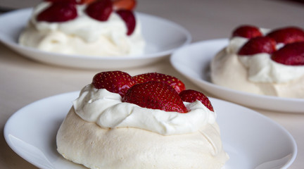  Pavlova cakes with meringue, whipped cream and fresh strawberri