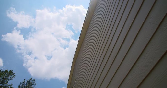 House Fiber Cement Siding Look Up Panning. looking up at the side of a home as the camera pans right from the sky towards the siding of a home in the south.
