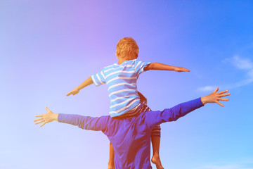 happy father and son playing on sky