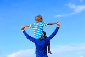 happy father and son playing on sky