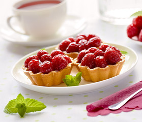 Fruit raspberries tarts or cupcakes on a table 