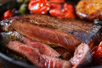 Beef steak with vegetables on a cast-iron frying pan