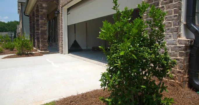 Home Garage Door Closes Angled Rising. rising shot on an angled front exterior of a new residential home as the garage door closes

