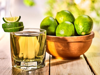 Country drink. On wooden boards is glass with green transparent drink and lime glue bowl. A drink number six . Country life. Light background.