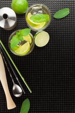 Mojito cocktail and ingredients over black rubber mat