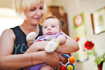 Granny plays with a newborn baby © pavasaris