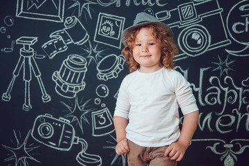Little boy in hat on a dark background with the words