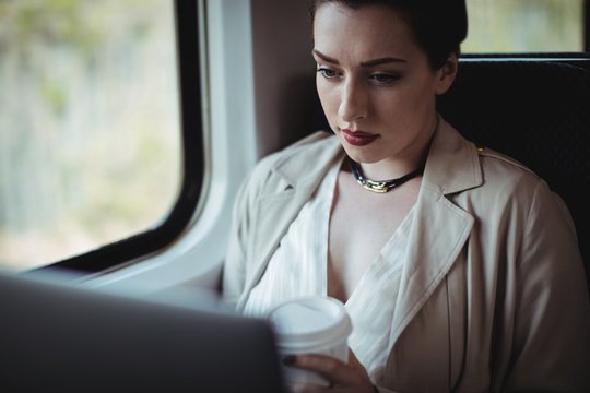 Woman holding disposable cup in train