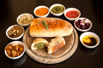 Italian food ingredients background with sliced bread Ciabatta rosemary on wooden board
