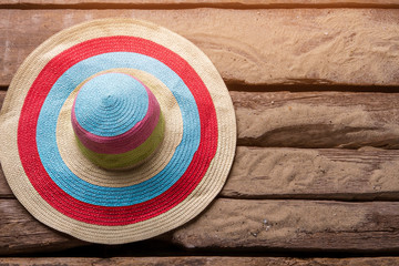 Fototapeta na wymiar Striped beach hat. Hat on sand background. Woman's summer headwear. Hide away from the sun.