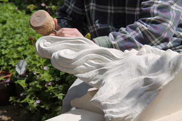 A Craftsman Using a Chisel to Carve a Stone Head.