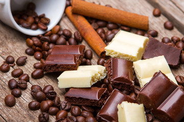 Roasted coffee beans and chocolate. White chocolate and cinnamon stick. Part of morning dessert. Snack for sweet tooth.