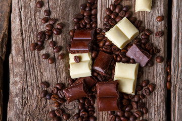Coffee beans and brown chocolate. Pieces of dark chocolate. Product high in calories. Confectionery of high quality.
