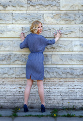 Elegant young model posing near stone wall