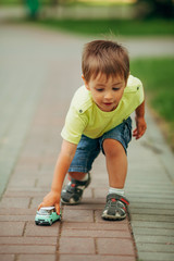Fototapeta premium little boy playing with toy car