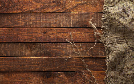 Dark wood with old burlap texture, top view