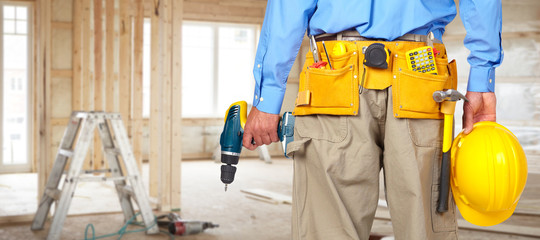 Construction worker with helmet and drill.