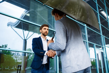 Picture of two young businessmen meeting at station background