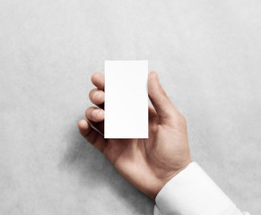 Hand holding blank vertical white business namecard mock up. Clear calling card mockup template hold arm. Visiting pasteboard paper surface display front. Small pure offset card holder presentation