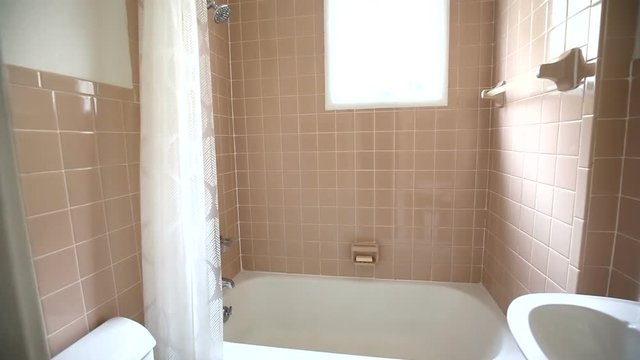 Out Dated Bathroom Push In Through Door. camera moves in slowly showing and out dated bathroom with pink tiles
