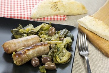 Pork sausages with olives, escarole and bread