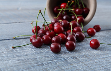 Fresh cherries closeup with green leaves on blue rustic wood