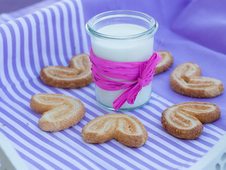 milk carafe and cookies on a table purple striped napkin