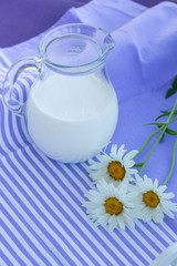 Obraz na płótnie Canvas milk carafe on a table purple striped napkin