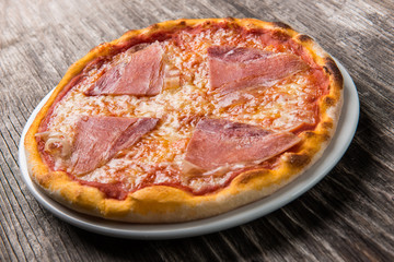 Delicious pizza with prosciutto and cheese on plate