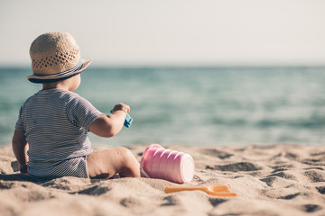Fototapeta na wymiar Boy playing with toys on beach