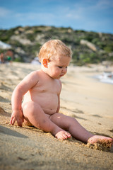 Fototapeta na wymiar Little naked boy in water on beach