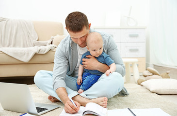 Father holding sweet baby and working