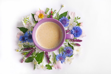Obraz na płótnie Canvas Cup of coffee with fresh flowers lying around on white background