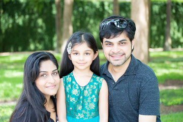 Closeup portrait, adorable family posing outdoors, isolated green trees outside outdoors background