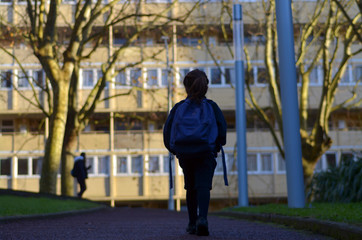 Little girl walks to school alone by herself in the street