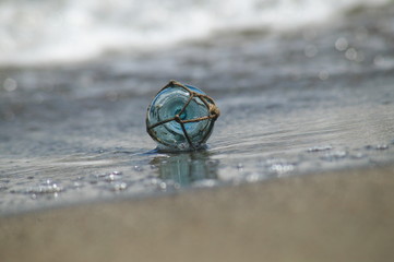 波打ち際の小さなガラスの浮き球