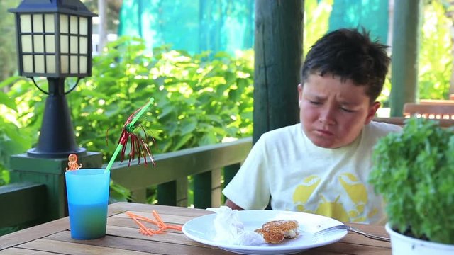 Over eating kid having a painful stomach ache,  hands on abdomen