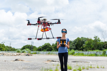 Woman controlling drone quadcopter flying