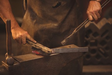 Blacksmith working on a heated iron rod