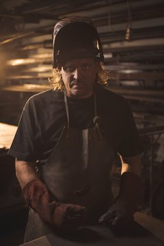Portrait of blacksmith in protective helmet