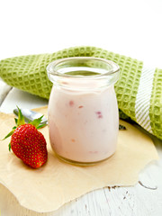 Yogurt with strawberries in jar on light board