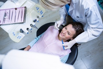 Dentist examining a patient with tools