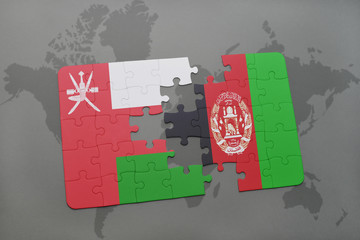 puzzle with the national flag of oman and afghanistan on a world map background.