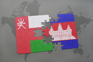 puzzle with the national flag of oman and cambodia on a world map background.