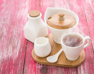 Tea cups with teapot on old wooden table