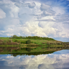 Obraz na płótnie Canvas Beautiful lake, spring meadow and cloudy sky