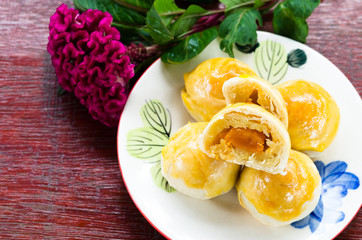 Selected focus of chinese pastry cake with pink flower on wooden floor