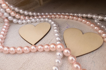 Beautiful wooden heart shapes with necklaces as decorations.
